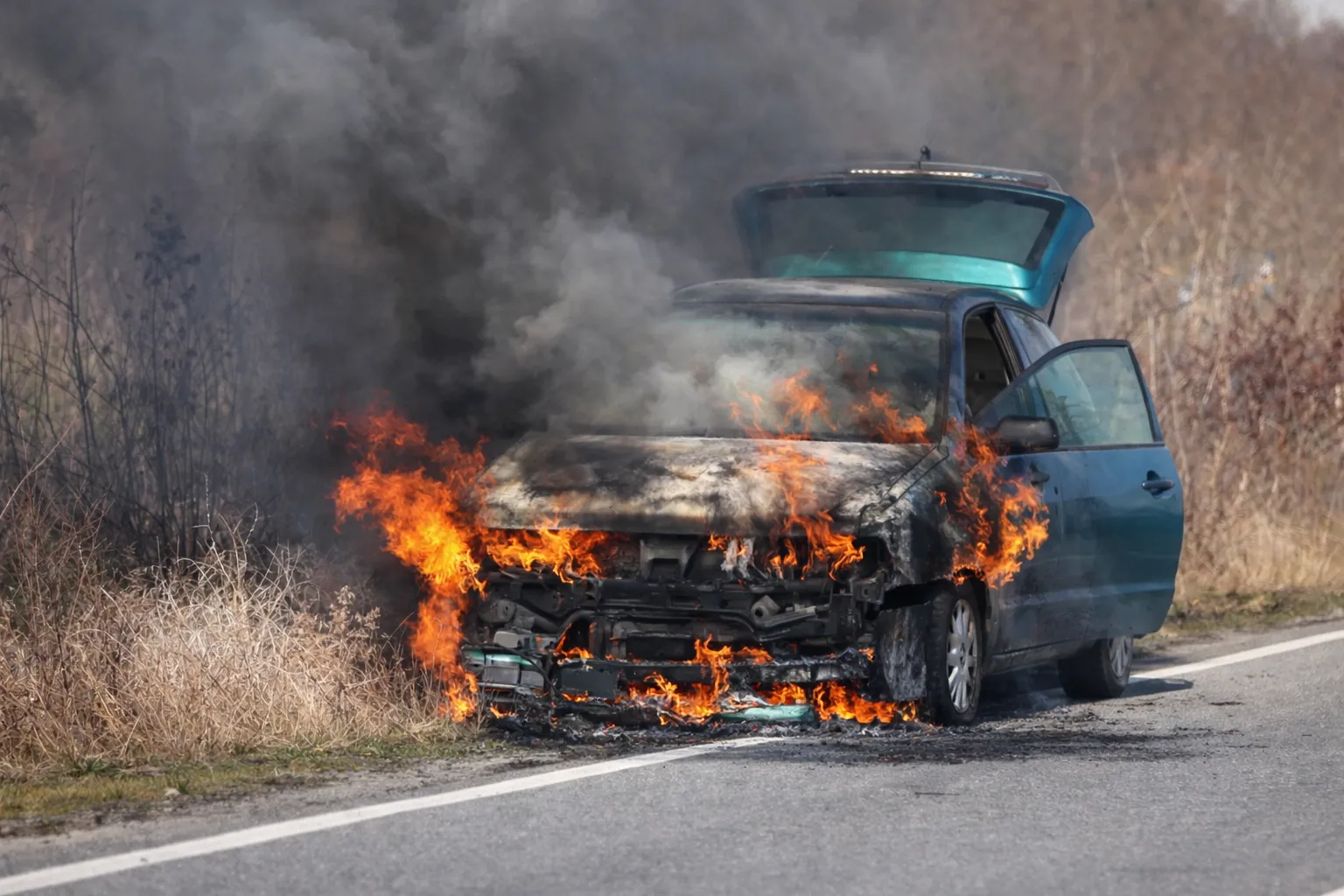 Coche azul en llamas en la carretera, ilustrando los mitos sobre seguridad