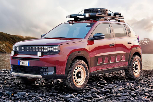 Fiat Panda rojo con baca, rueda de repuesto y neumáticos de taco sobre una orilla de piedras, con un lago y montañas detrás