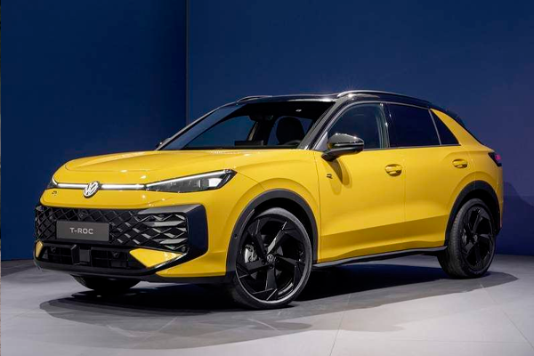 Volkswagen T-Roc amarillo con llantas negras de diseño y techo oscuro, expuesto en un estudio de fondo azul marino