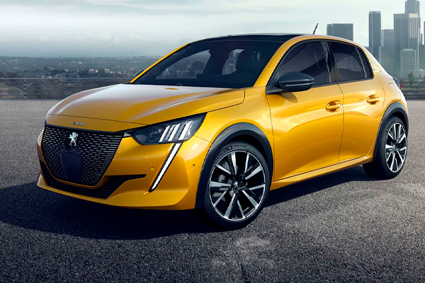 Peugeot 208 amarillo con faros en forma de garra y llantas de aleación, sobre asfalto con una ciudad al fondo