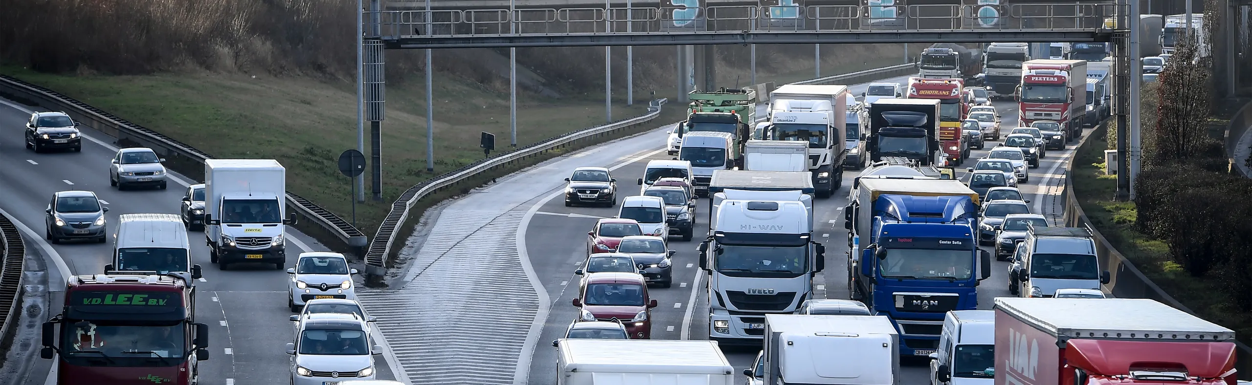 Tráfico congestionado en autopista con vehículos de carga y turismos circulando juntos