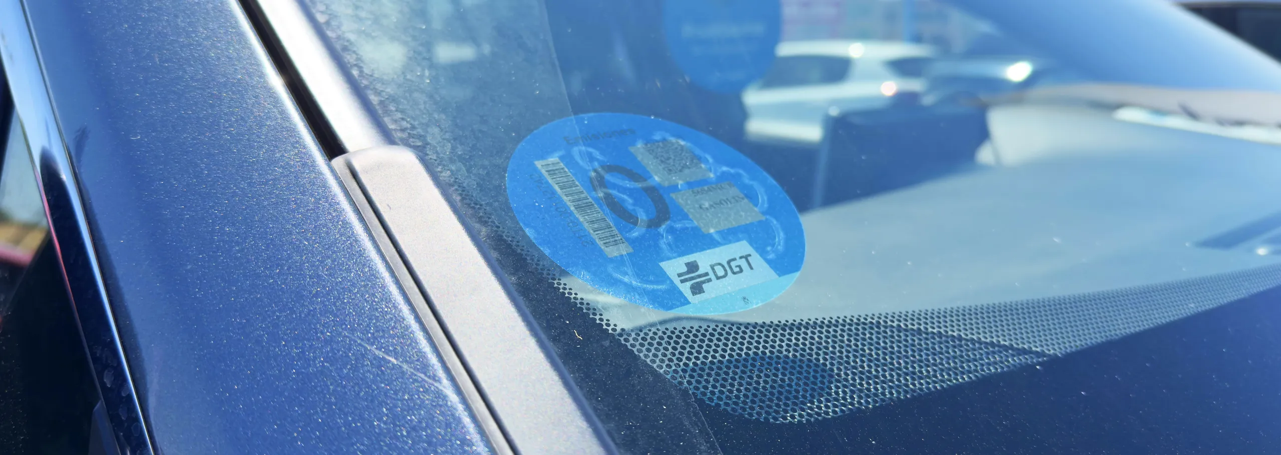 Pegatina ambiental DGT azul en parabrisas de vehículo