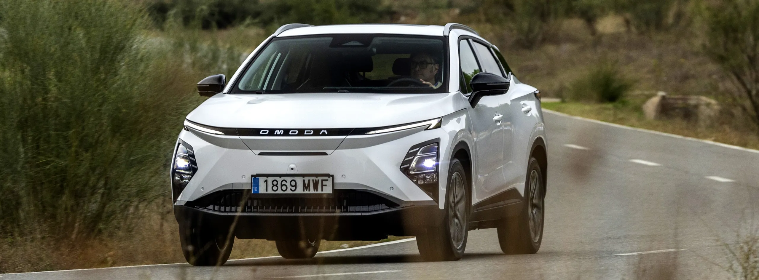 Omoda 5 blanco circulando por carretera, modelo eléctrico chino asequible