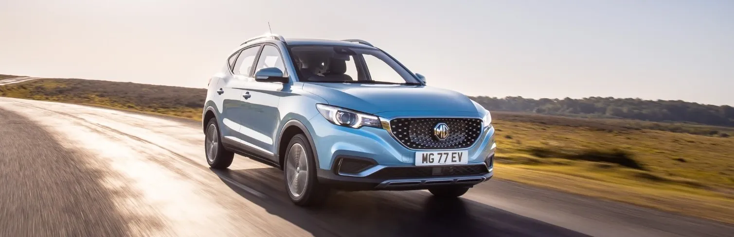 MG ZS EV azul circulando por carretera, SUV eléctrico chino de diseño moderno
