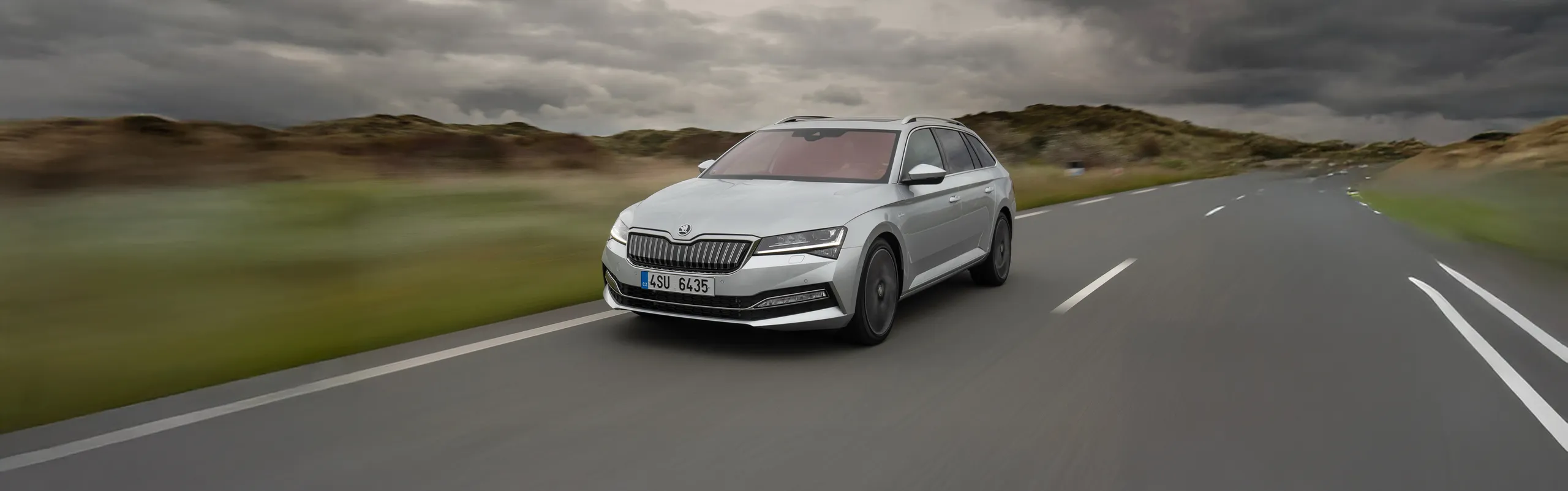 Skoda Superb blanco circulando por autopista con maletero amplio y espacioso