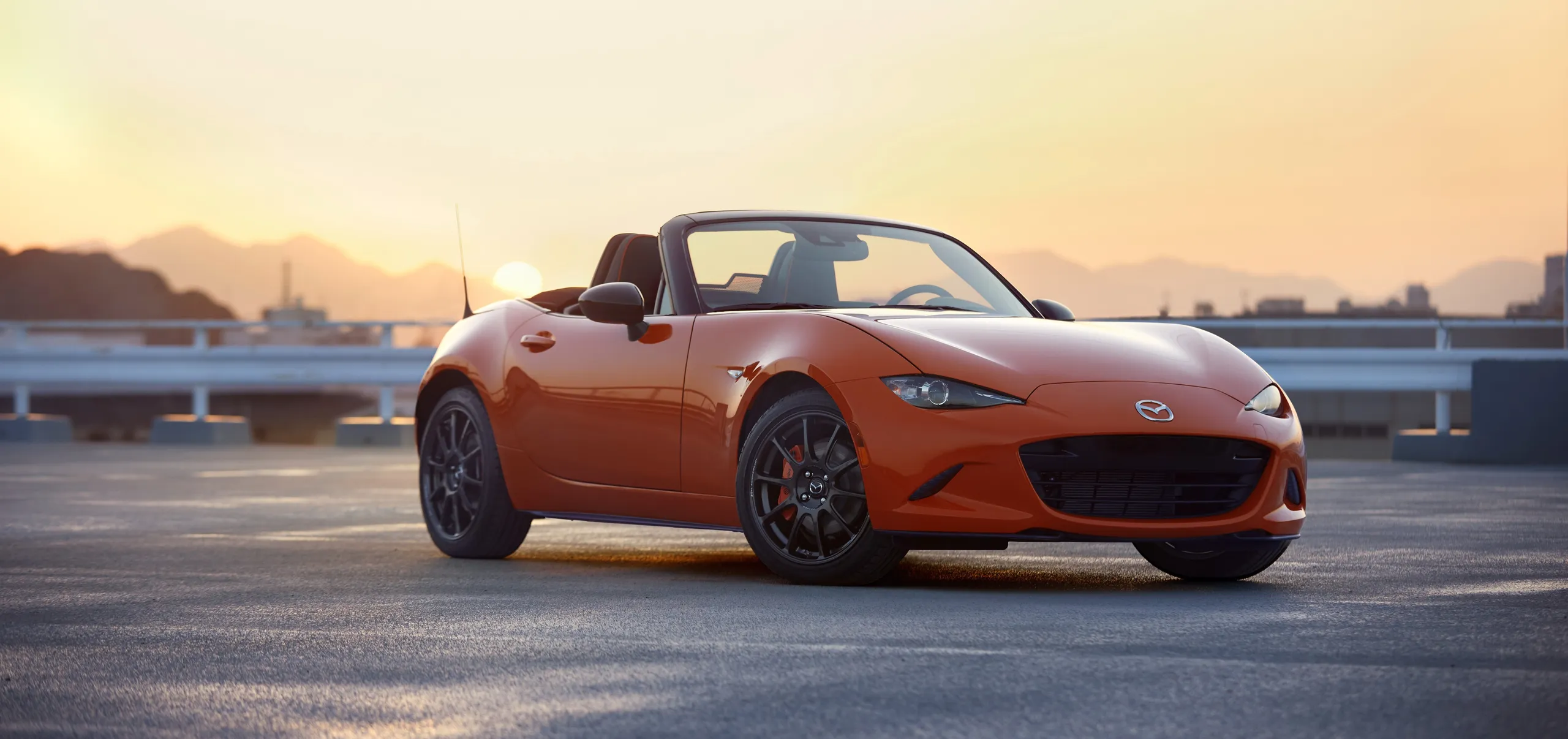 Mazda MX-5 rojo descapotable en parking al atardecer, deportivo barato segunda mano