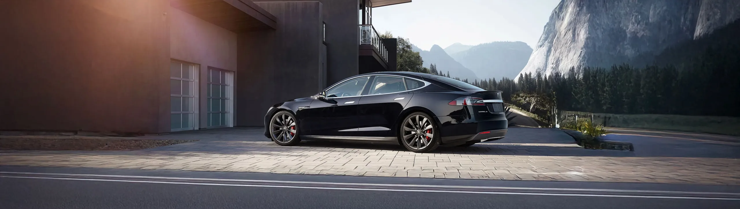 Tesla Model S negro aparcado en garaje moderno con vistas a montañas