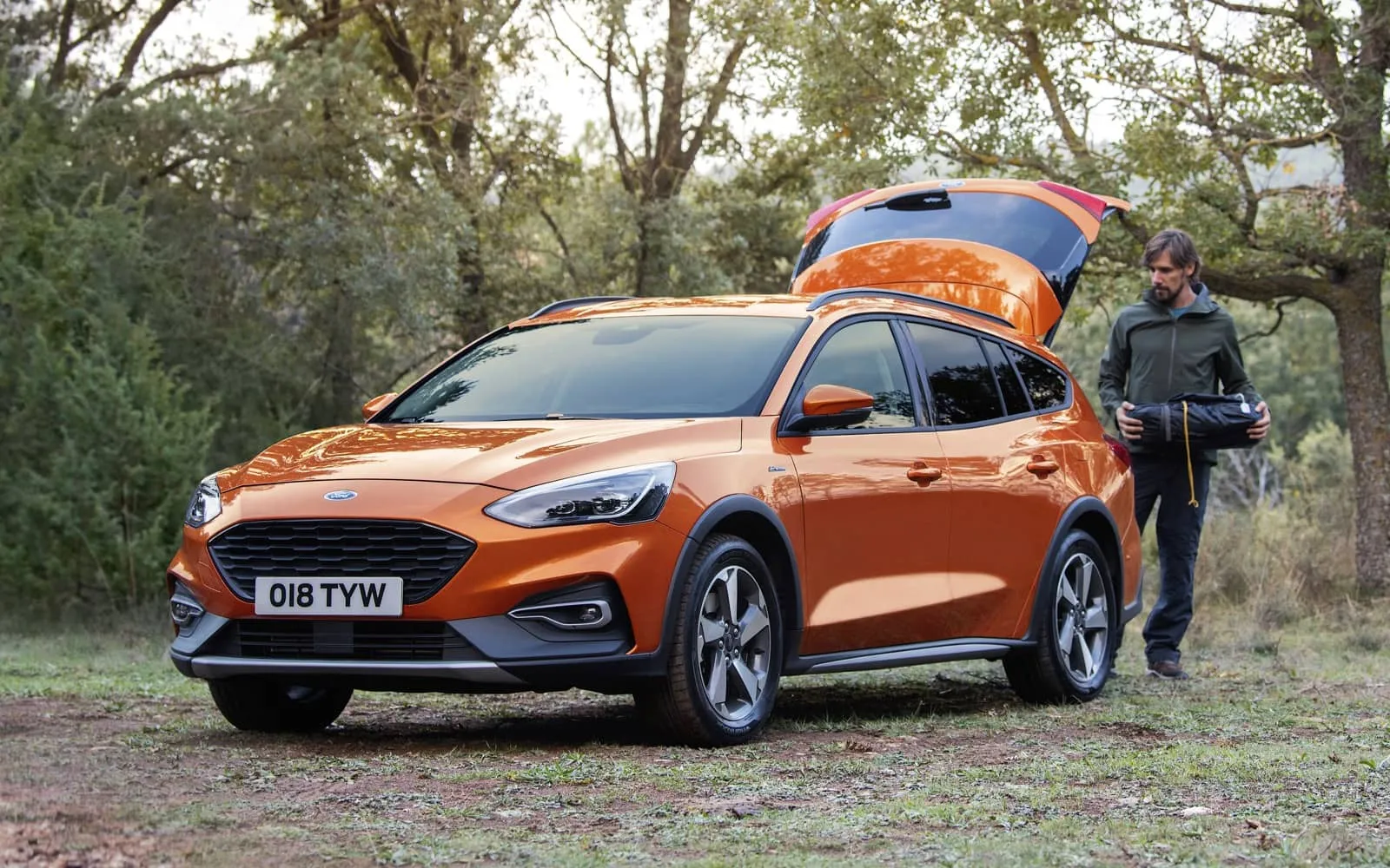 Ford Focus Active naranja con toldo de techo abierto en bosque, ideal para viajes
