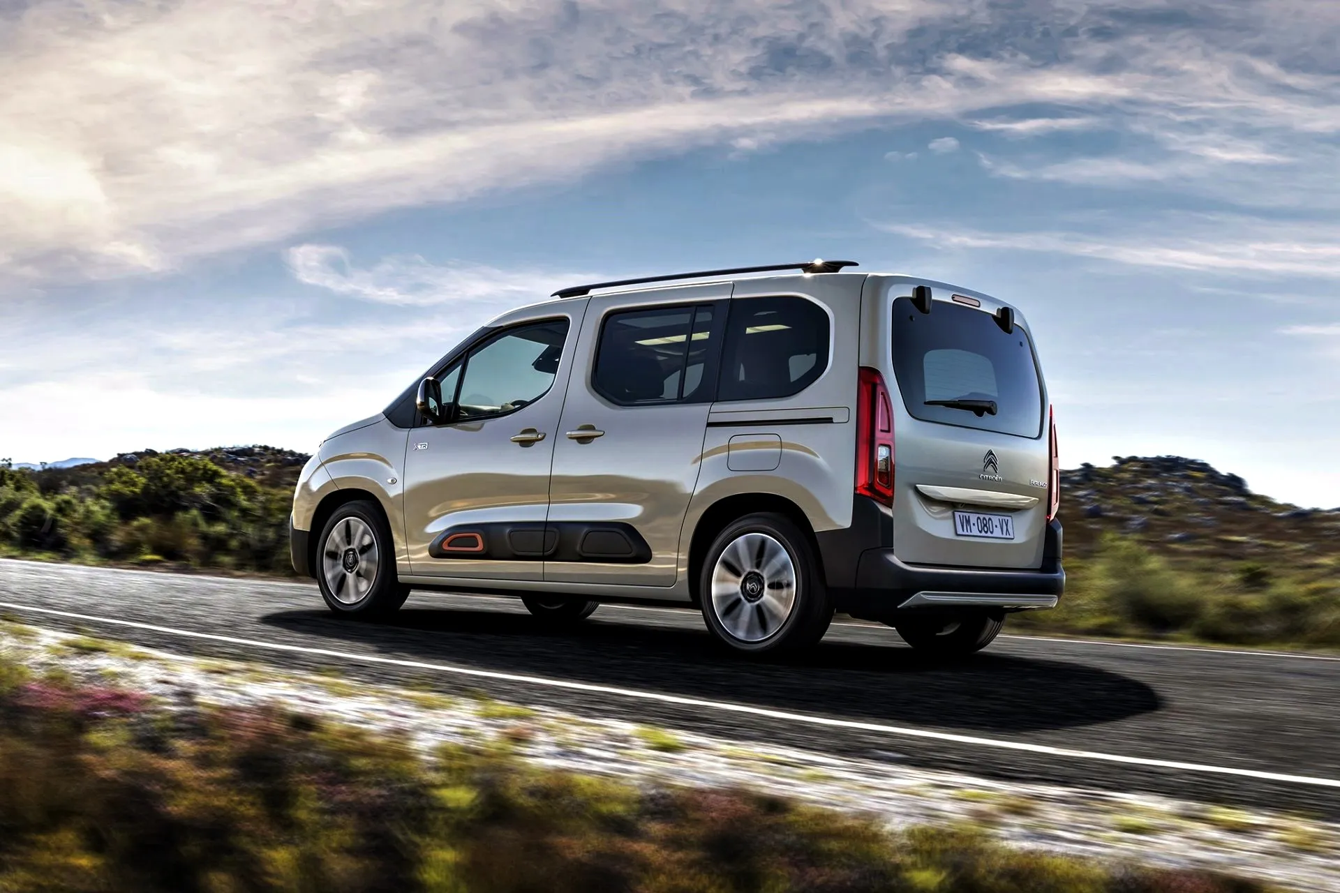 Citroën Berlingo gris plateado circulando por carretera con paisaje natural