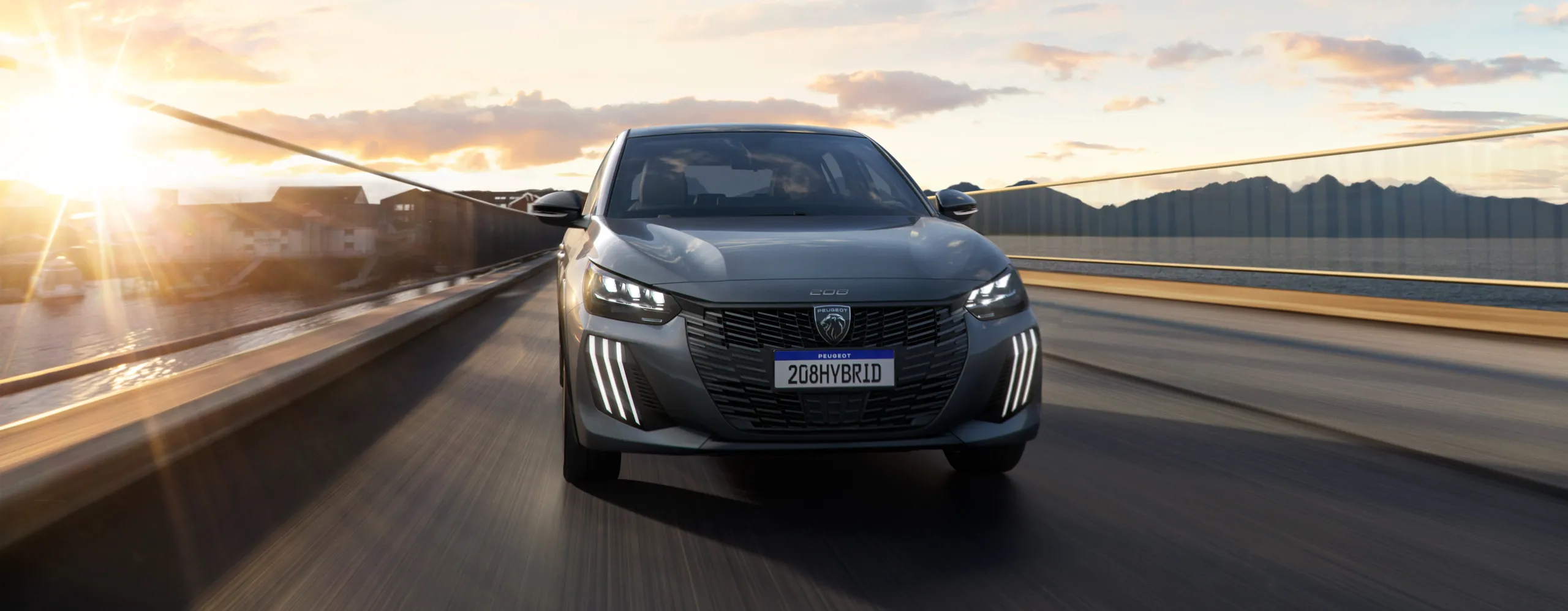 Peugeot 208 híbrido gris circulando por autopista al atardecer con diseño moderno
