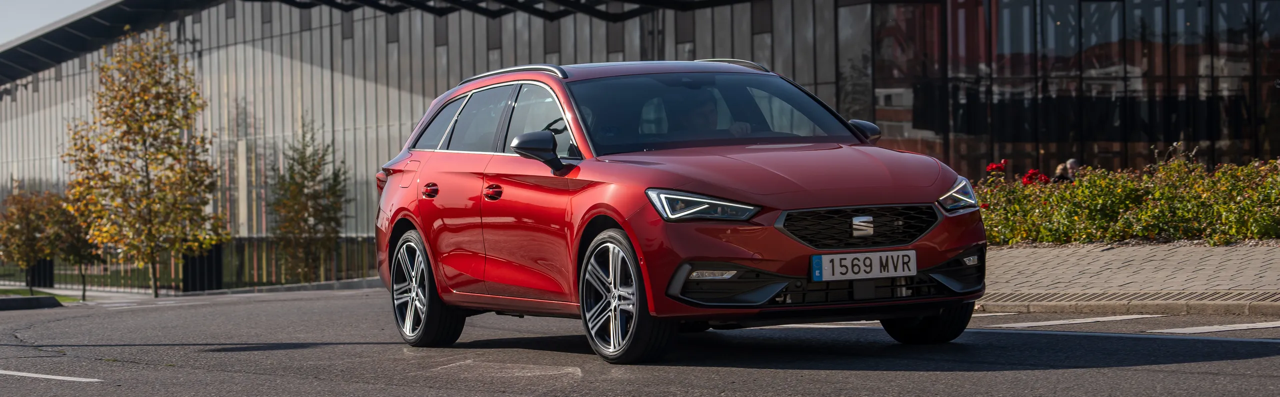 SEAT León rojo compacto deportivo aparcado en zona moderna