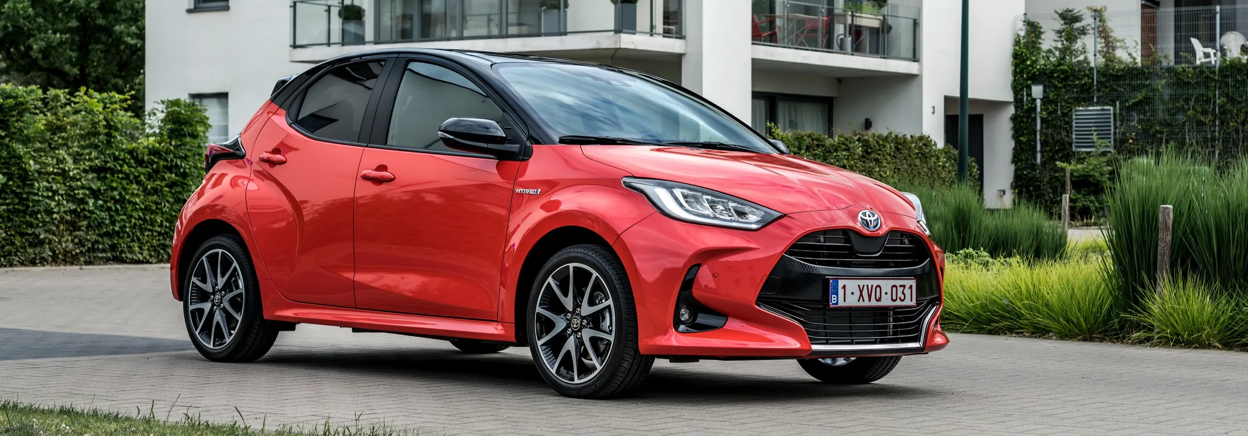 Toyota Yaris Hybrid rojo compacto aparacado en zona residencial moderna