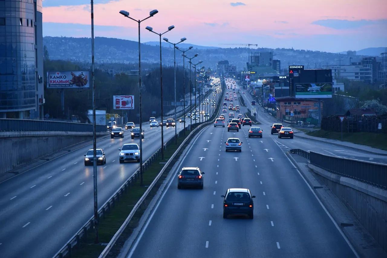 Autopista con múltiples carriles y tráfico denso al atardecer en una ciudad