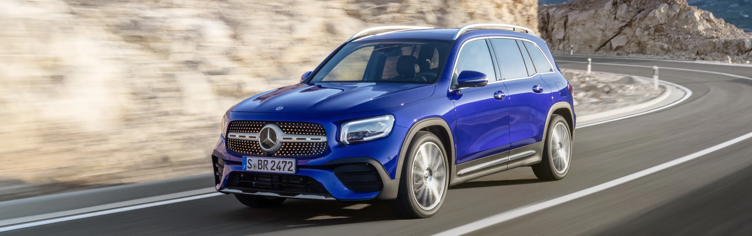 Mercedes-AMG GLB azul circulando por carretera de montaña