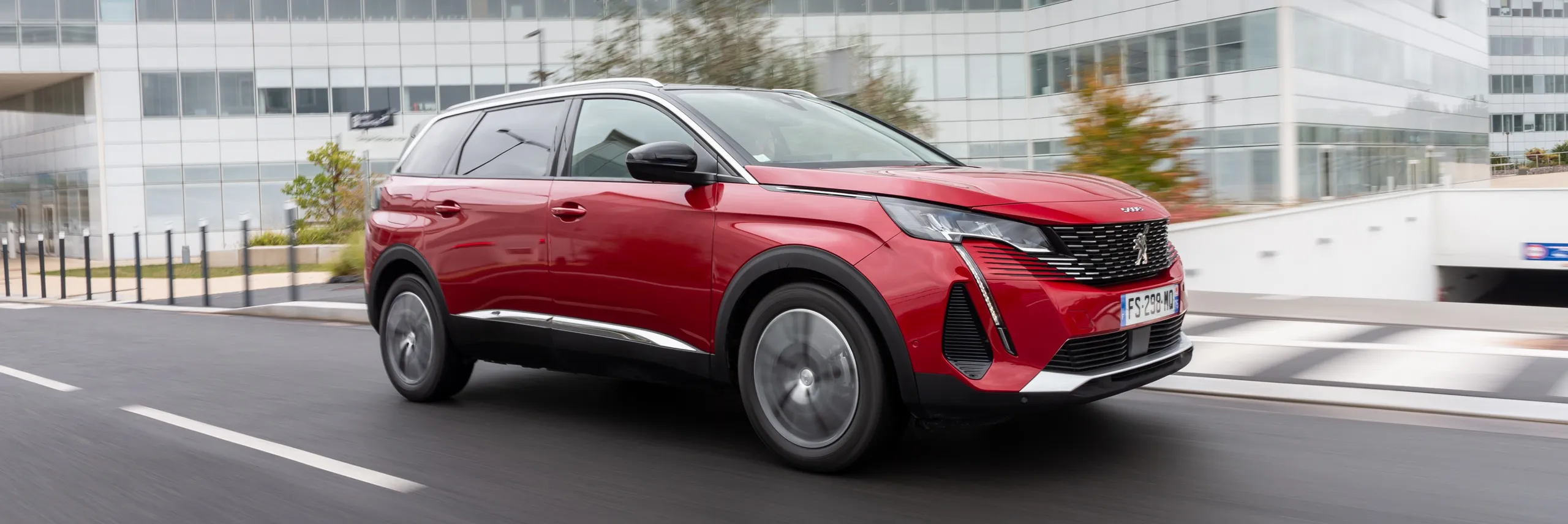 Peugeot 3008 rojo circulando por ciudad, ideal para familias numerosas