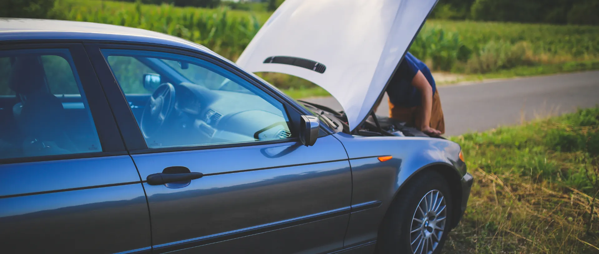 Coche con el capó abierto mostrando signos de problemas mecánicos