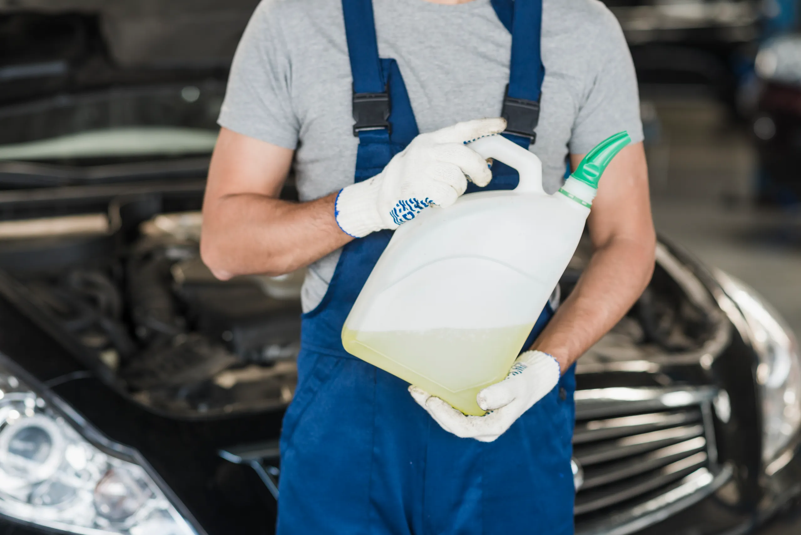 Mecánico sosteniendo recipiente de aceite mineral para motor de automóvil