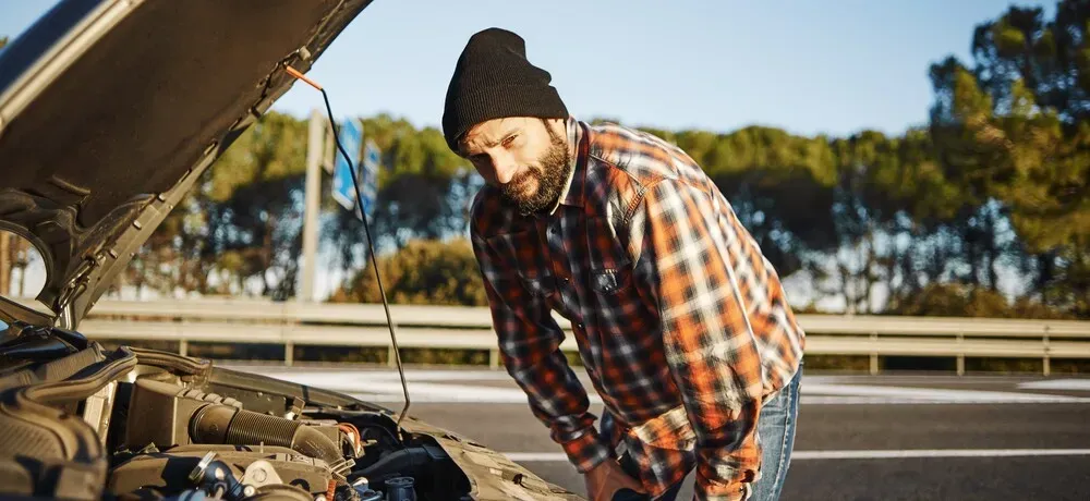Mecánico revisando el motor de un coche para mejorar su estado de venta