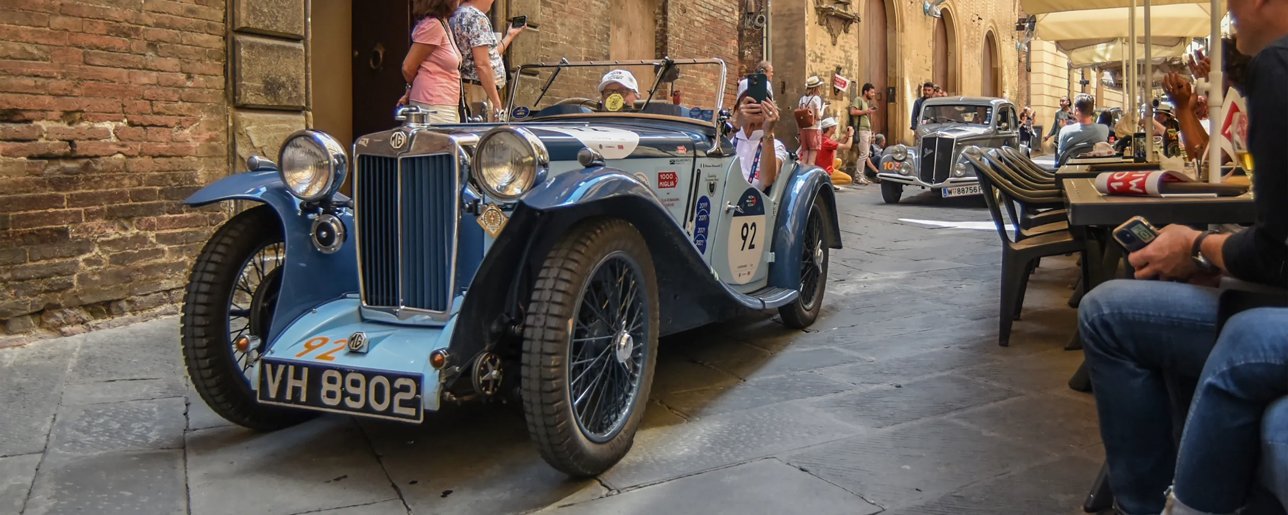 Vehículos clásicos MG de los años treinta en desfile de coches históricos por calle