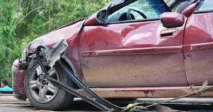 Vehículo rojo con daños graves en lateral tras accidente de tráfico
