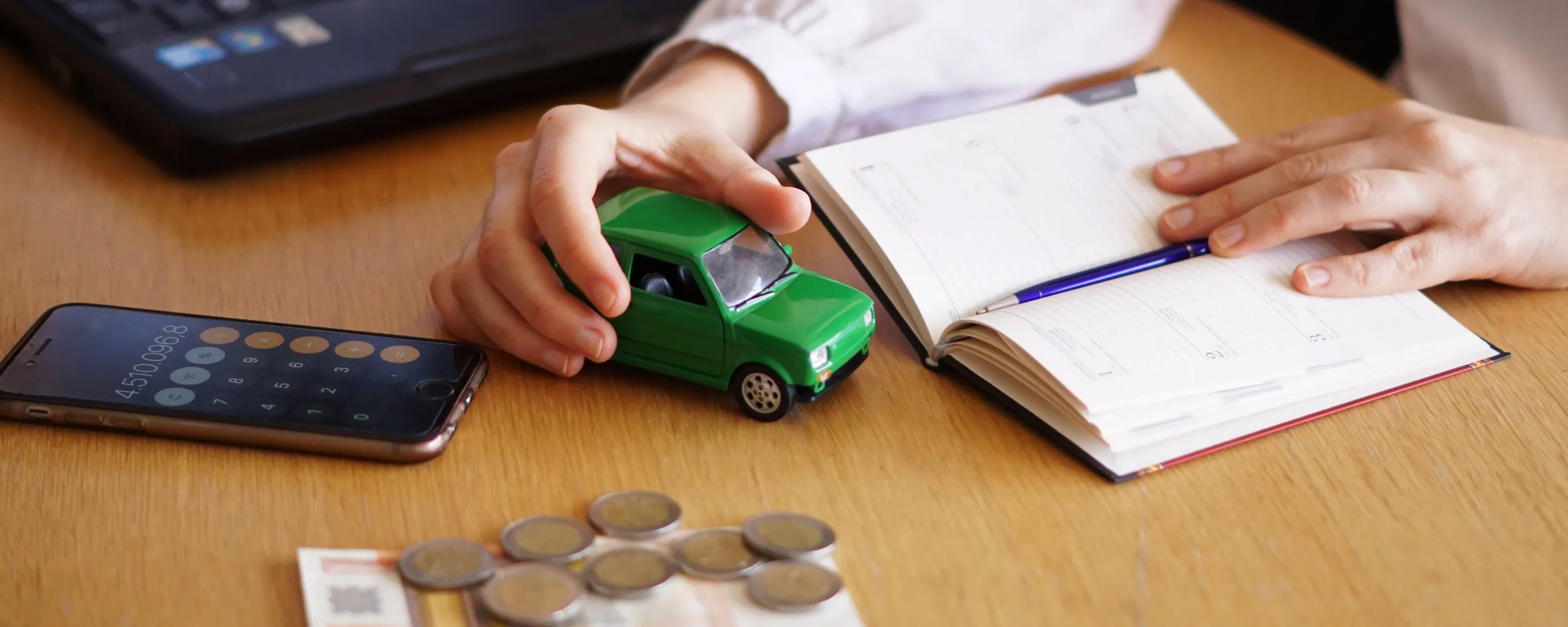 Persona calculando gastos de compra de coche con modelo 620, dinero y vehículo