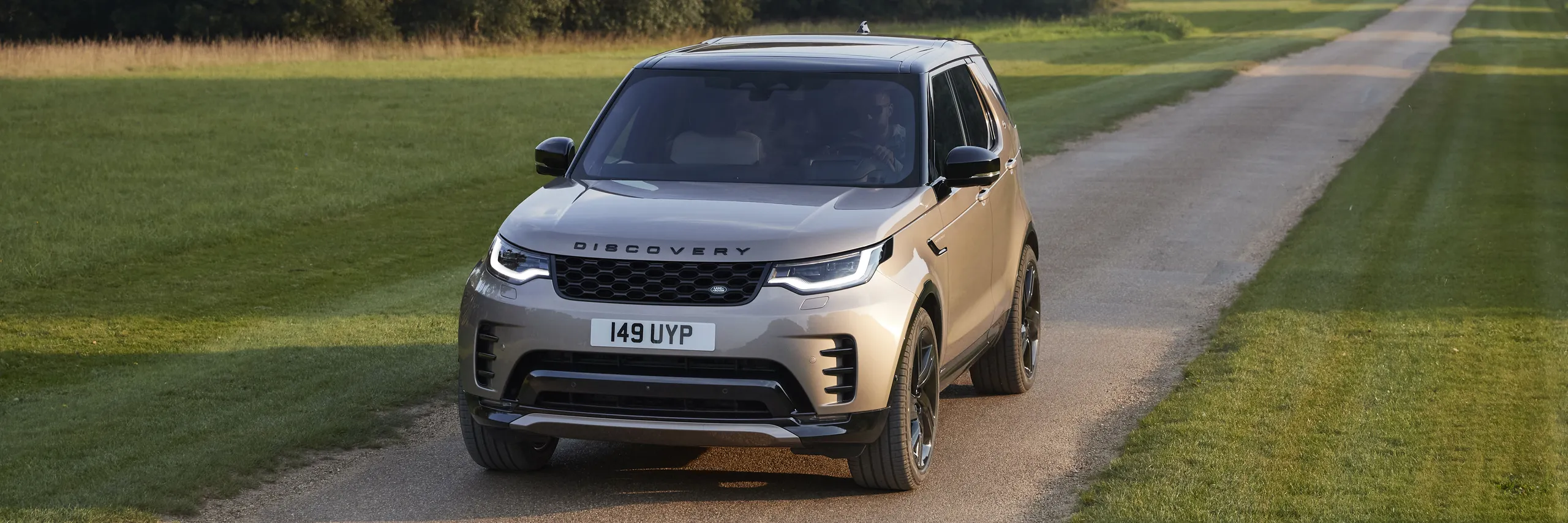 Land Rover Discovery beige en carretera rural, SUV premium de lujo con diseño robusto