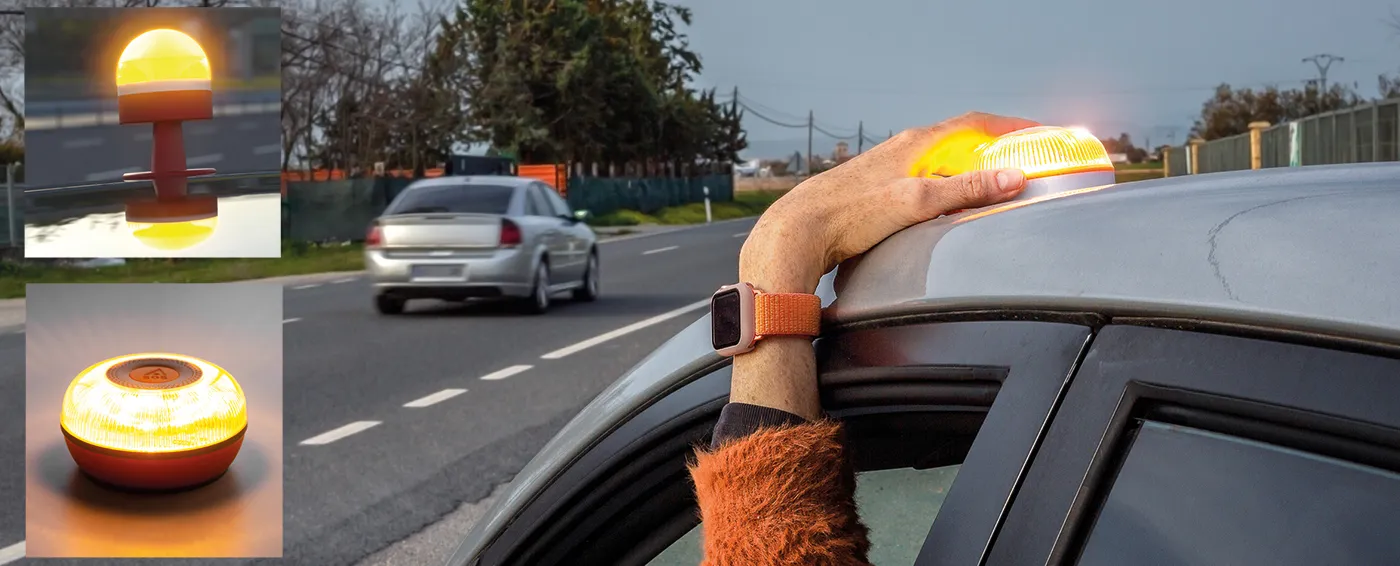 Luz de emergencia V-16 en color naranja siendo sostenida sobre el techo de un coche
