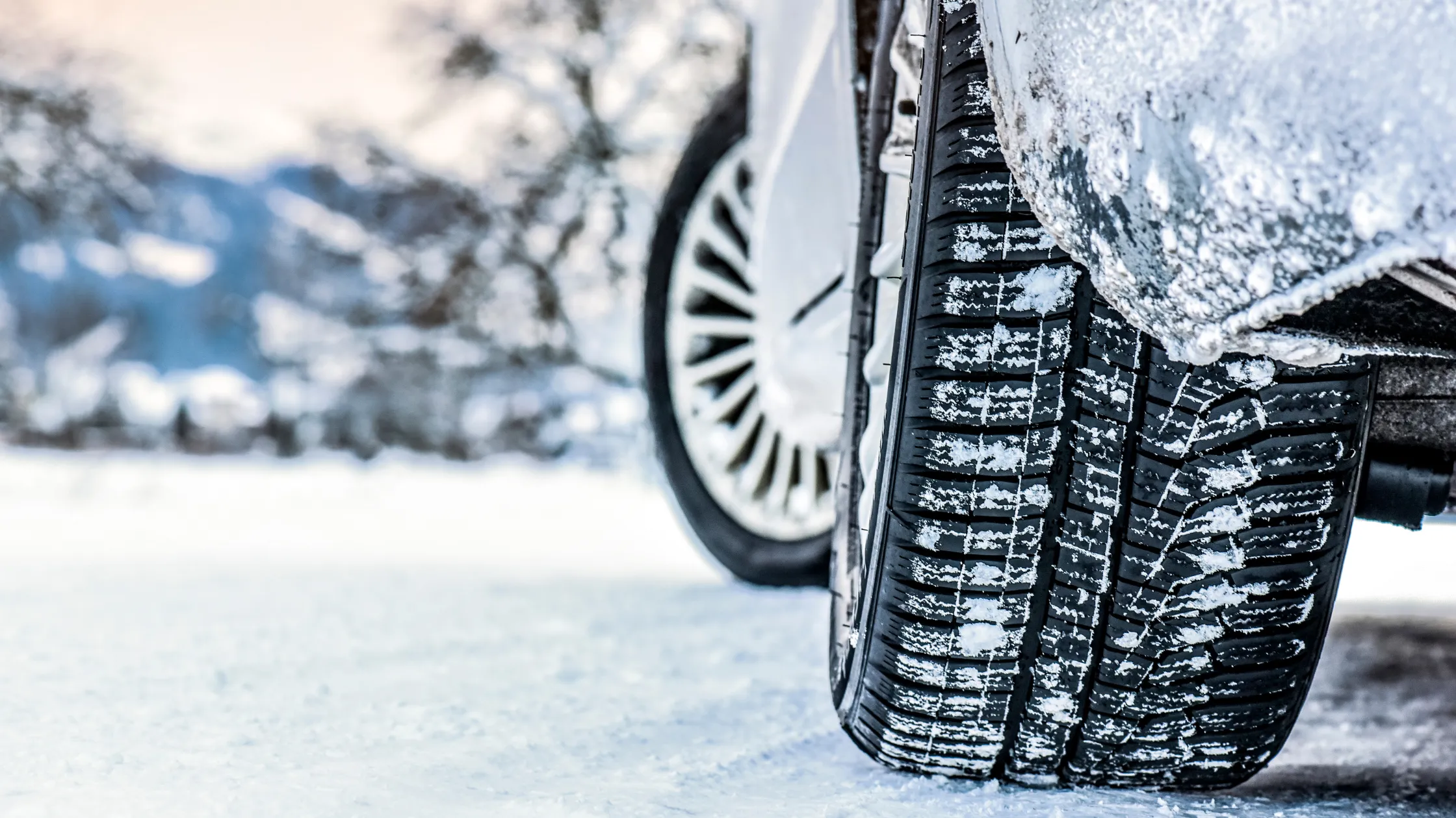 Neumáticos de invierno con nieve en una carretera helada durante la temporada invernal