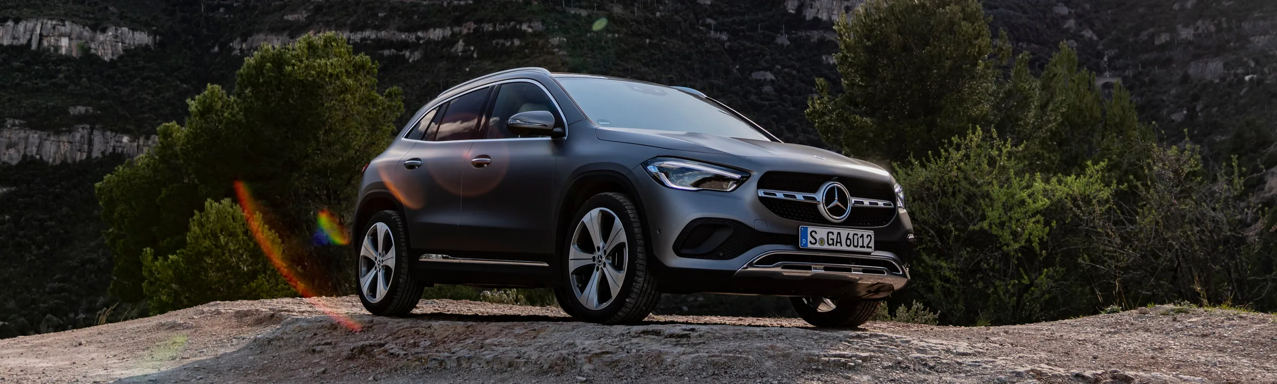 Mercedes GLA compacto gris en entorno montañoso rodeado de vegetación