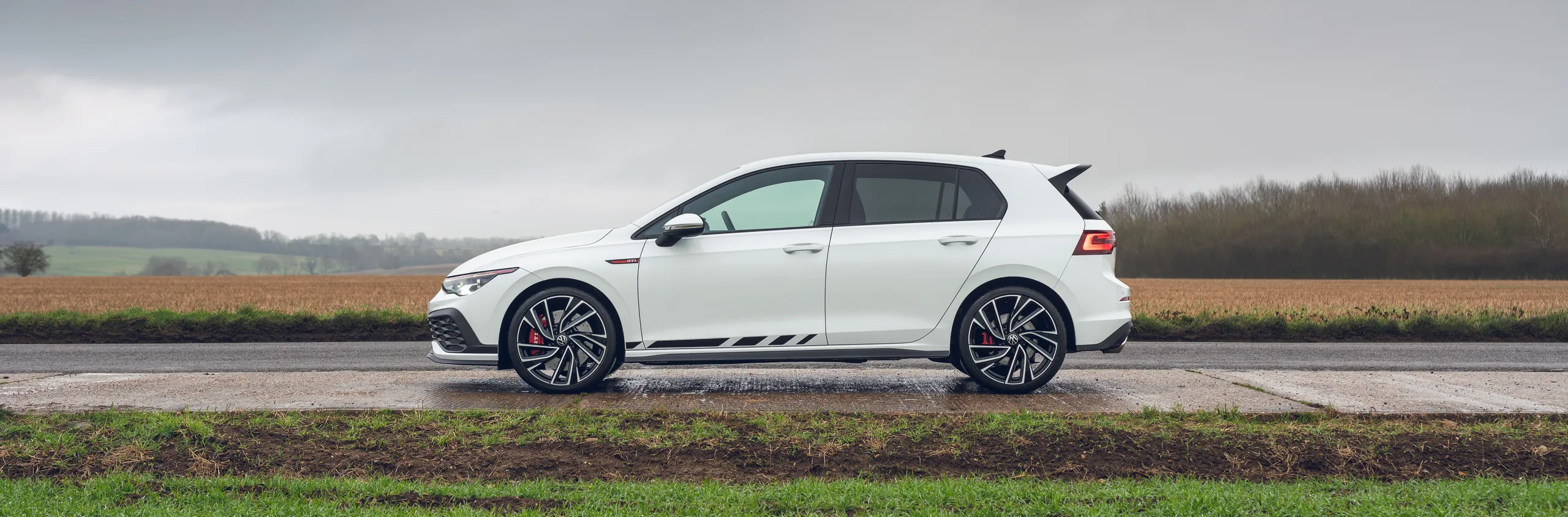 Ford Focus ST blanco visto de perfil en carretera rural
