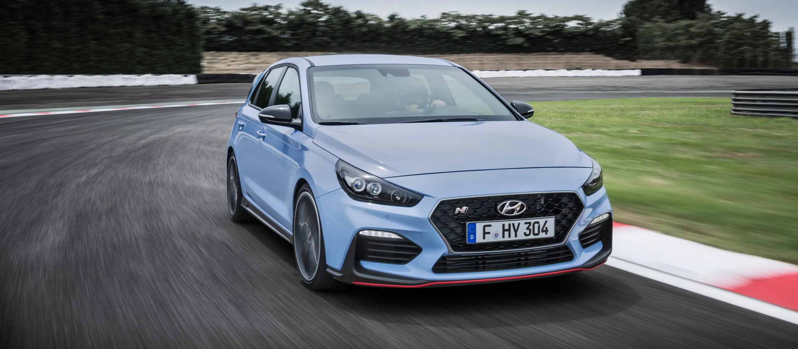 Hyundai i30 N azul circulando a alta velocidad en circuito de carreras
