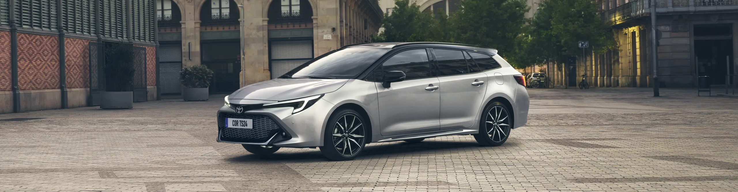 Toyota Corolla Touring blanco de ocasión aparcado en plaza urbana