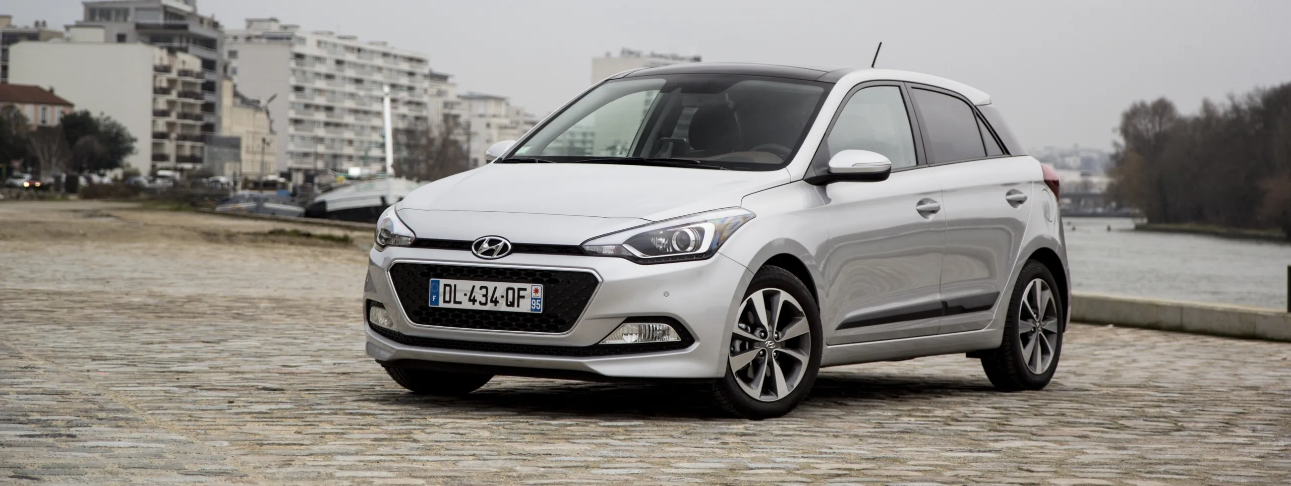 Hyundai i20 blanco de ocasión aparcado en zona urbana moderna