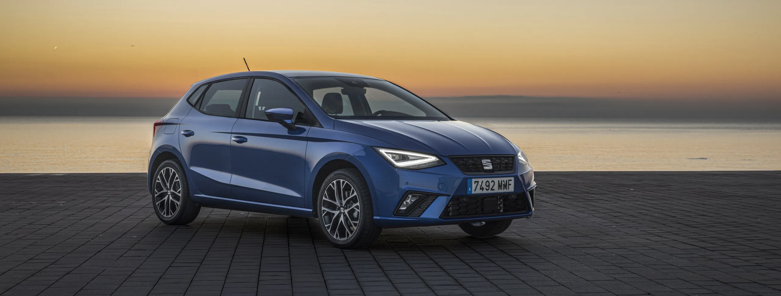 SEAT Ibiza azul compacto de ocasión estacionado al atardecer junto al mar