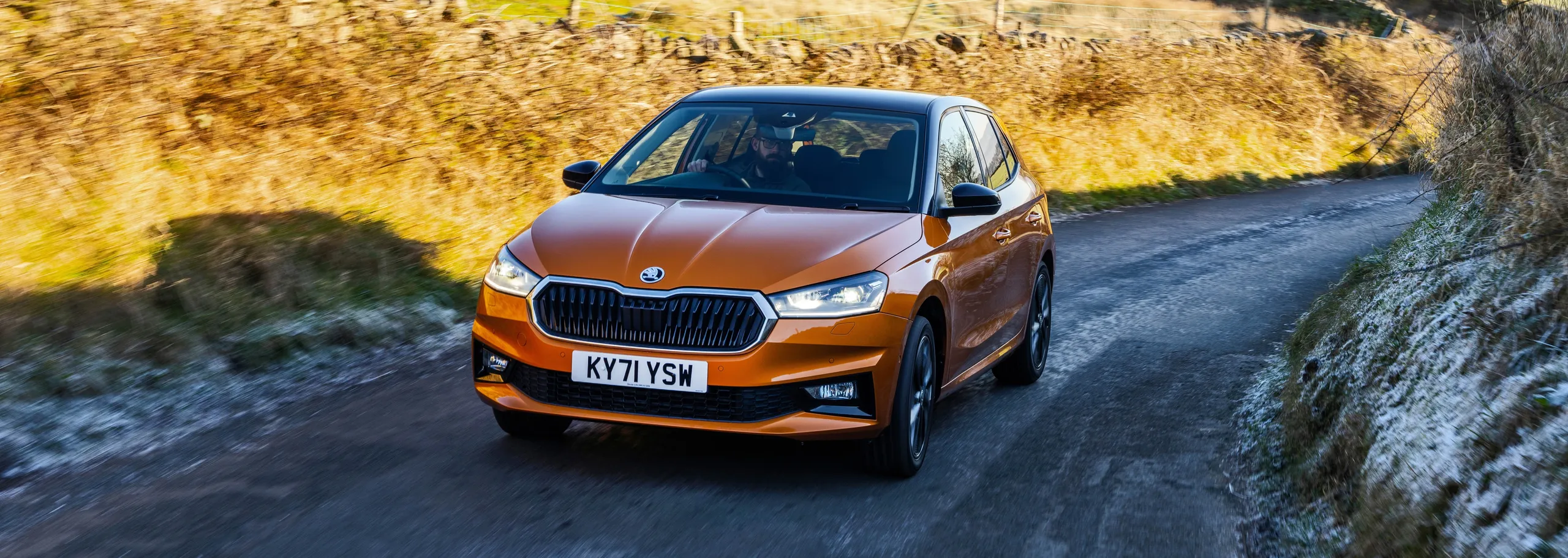 Škoda Fabia naranja circulando por carretera rural con diseño moderno y equipamiento