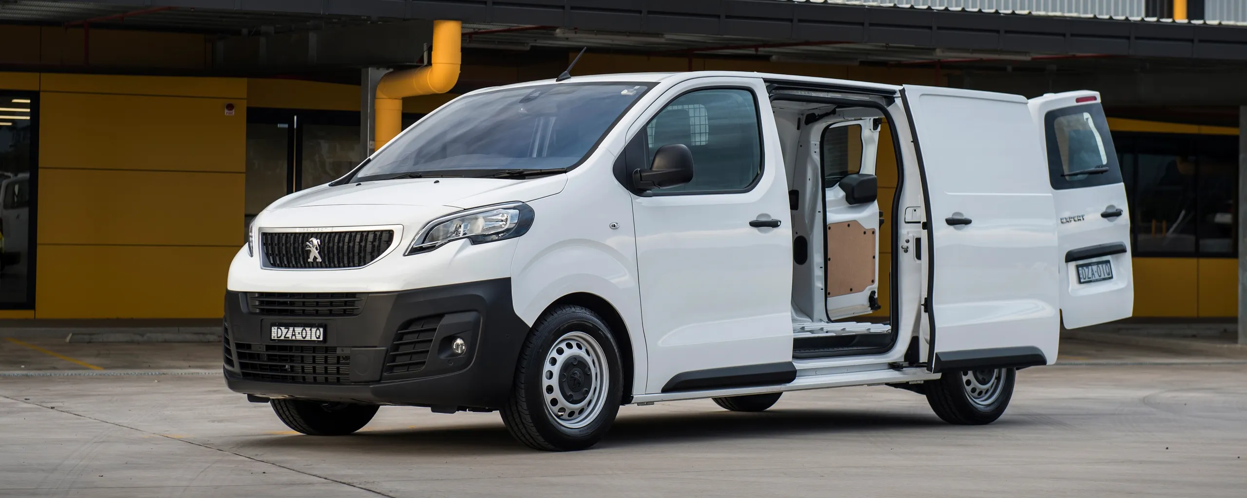Peugeot Expert blanca con puerta corredera abierta en parking