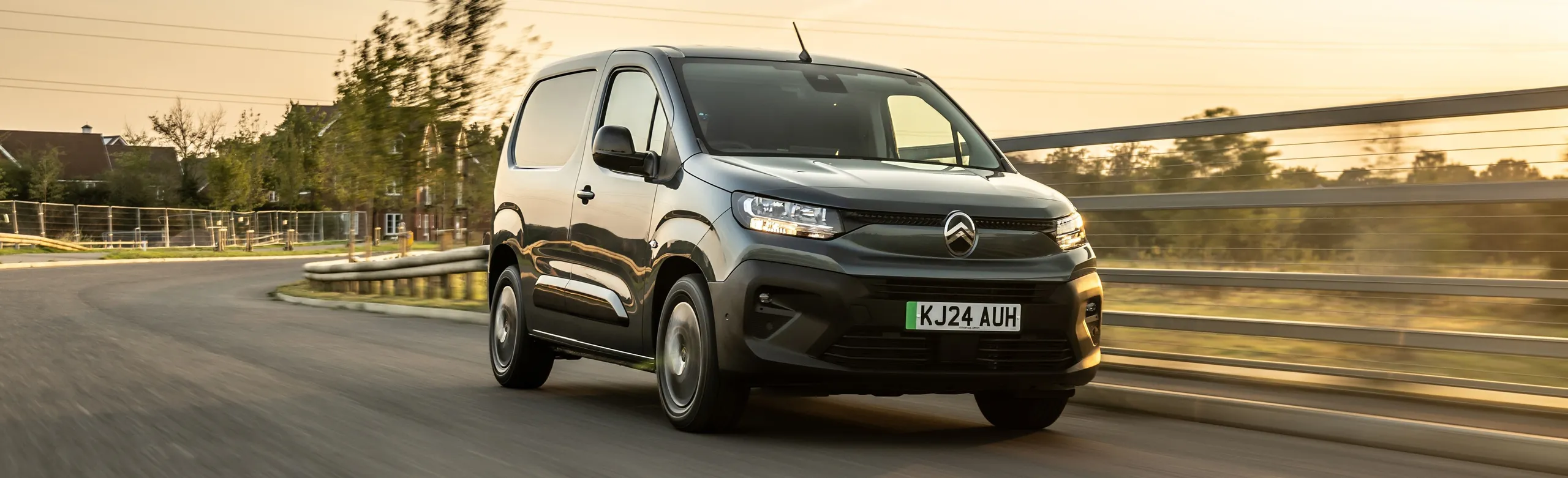 Citroën Berlingo eléctrica negra circulando por carretera en atardecer dorado