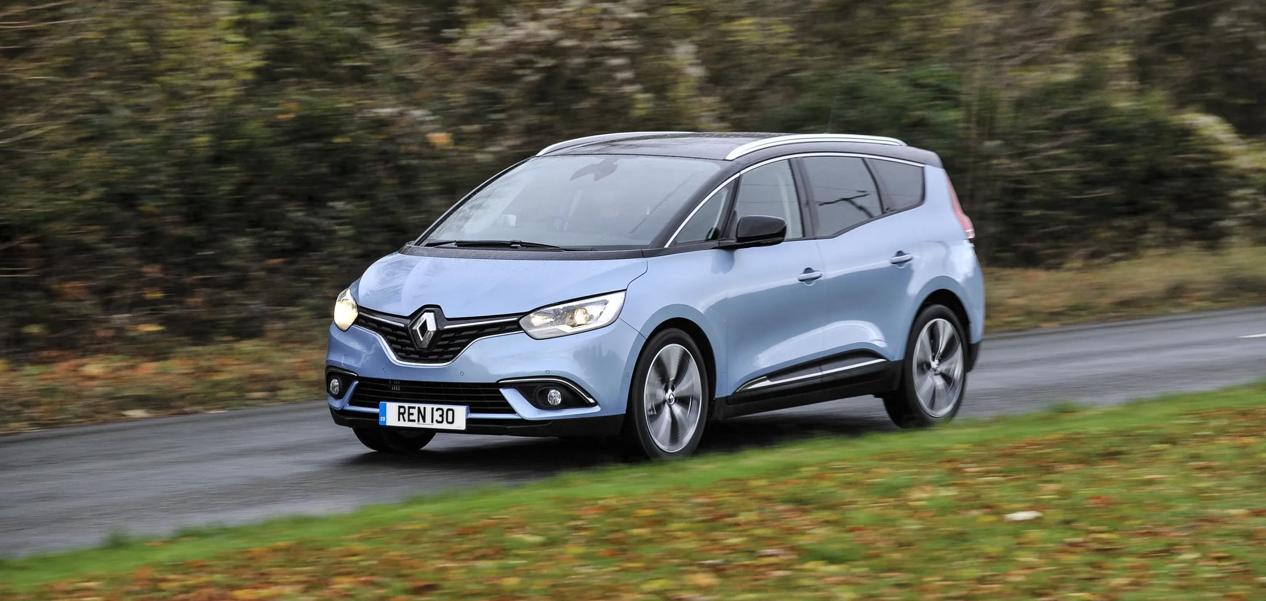 Renault Scenic monovolumen azul claro circulando por carretera rural