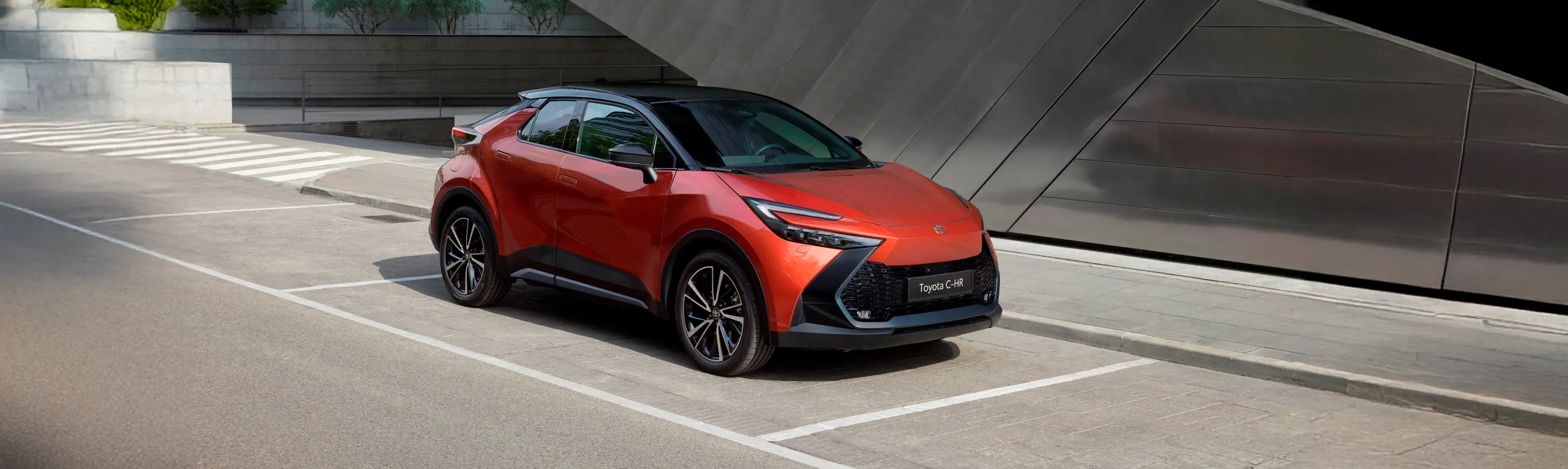 Toyota C-HR rojo en aparcamiento moderno, SUV compacto de diseño contemporáneo