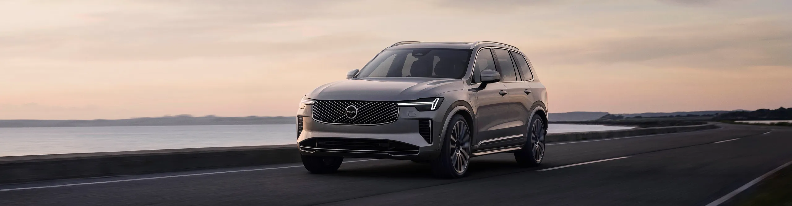Volvo XC90 gris en carretera costera con diseño escandinavo elegante