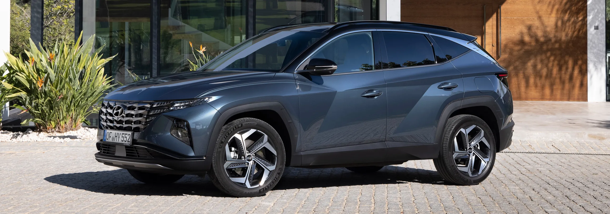 Hyundai Tucson azul metalizado en perfil lateral mostrando su diseño robusto y elegante