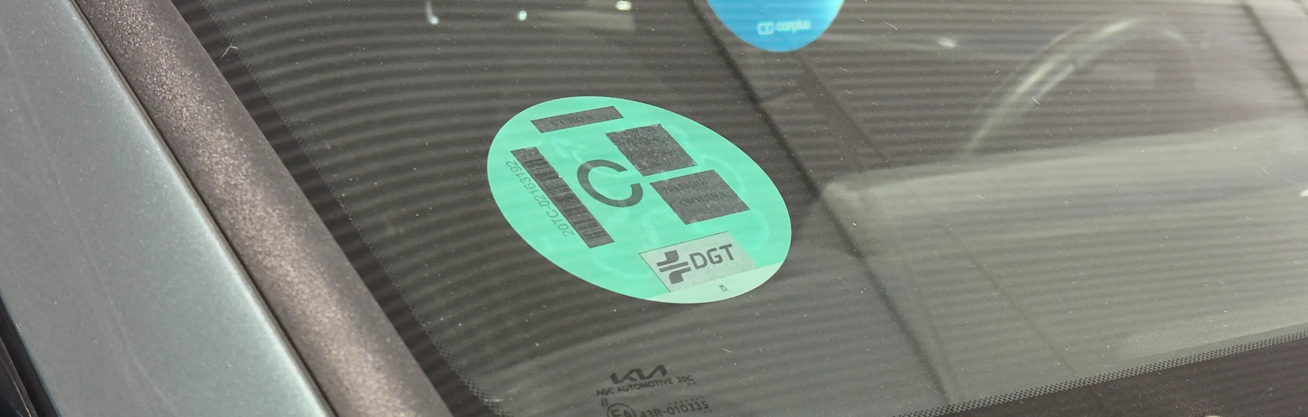 Pegatina verde DGT con símbolo eco en parabrisas de vehículo