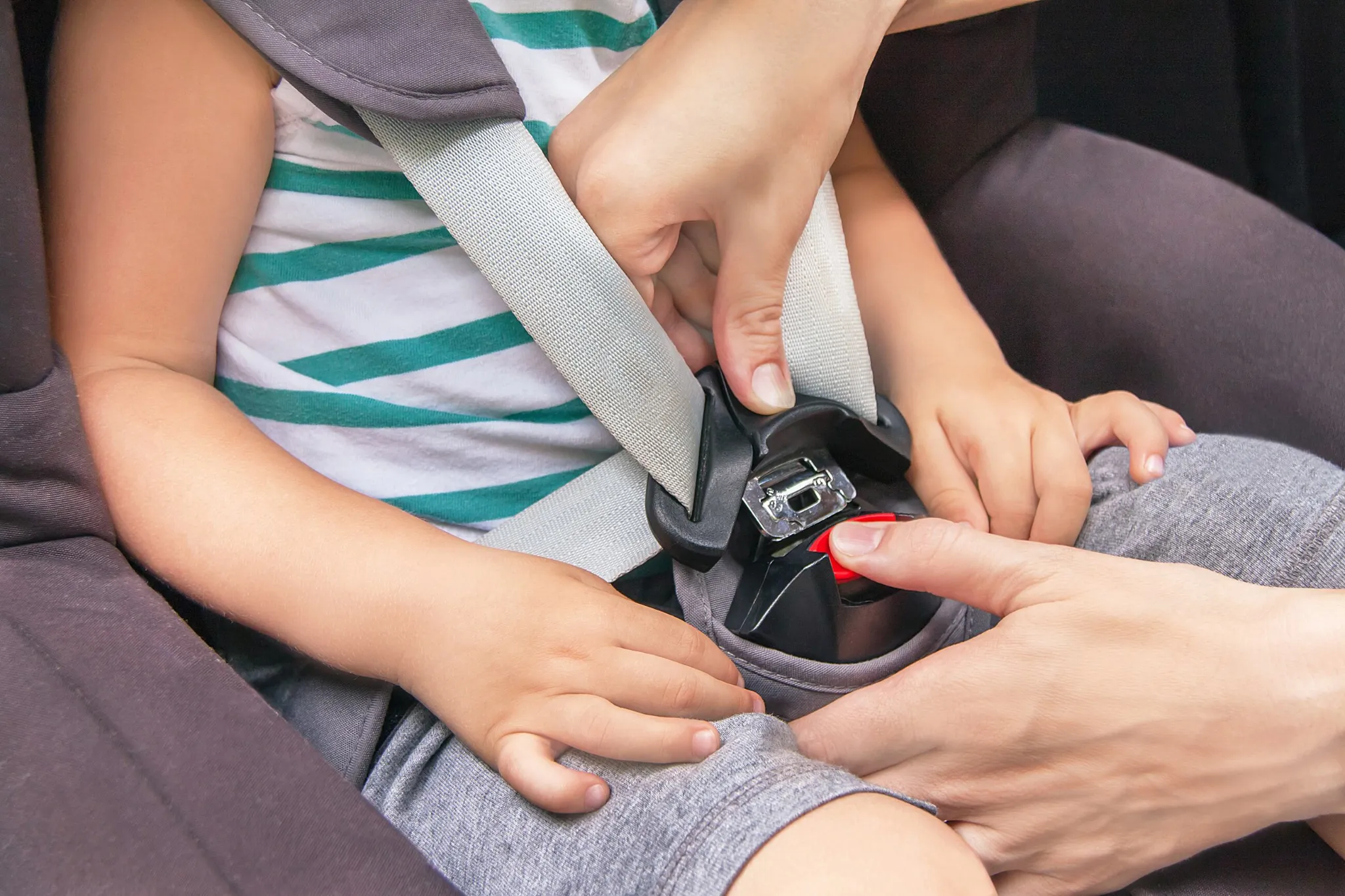 Padre abrochando el cinturón de seguridad infantil en el coche
