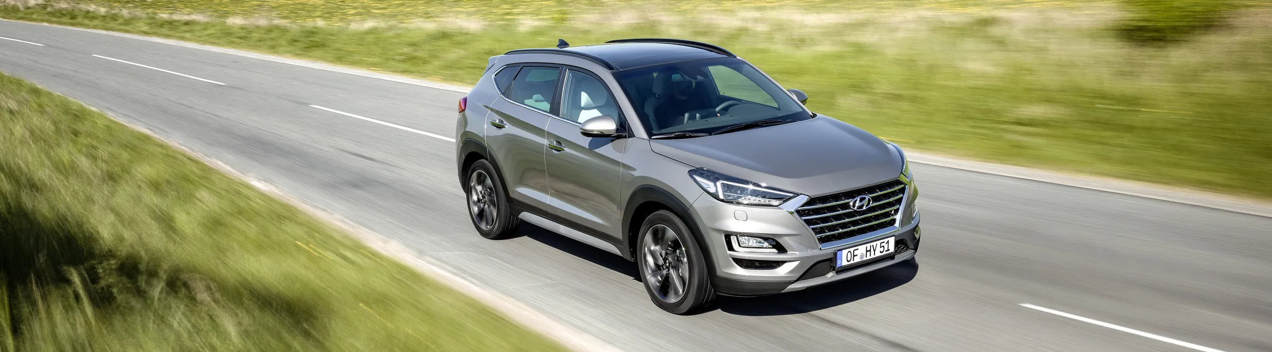 Hyundai Tucson plateado circulando por carretera, ejemplo de SUV híbrido eficiente