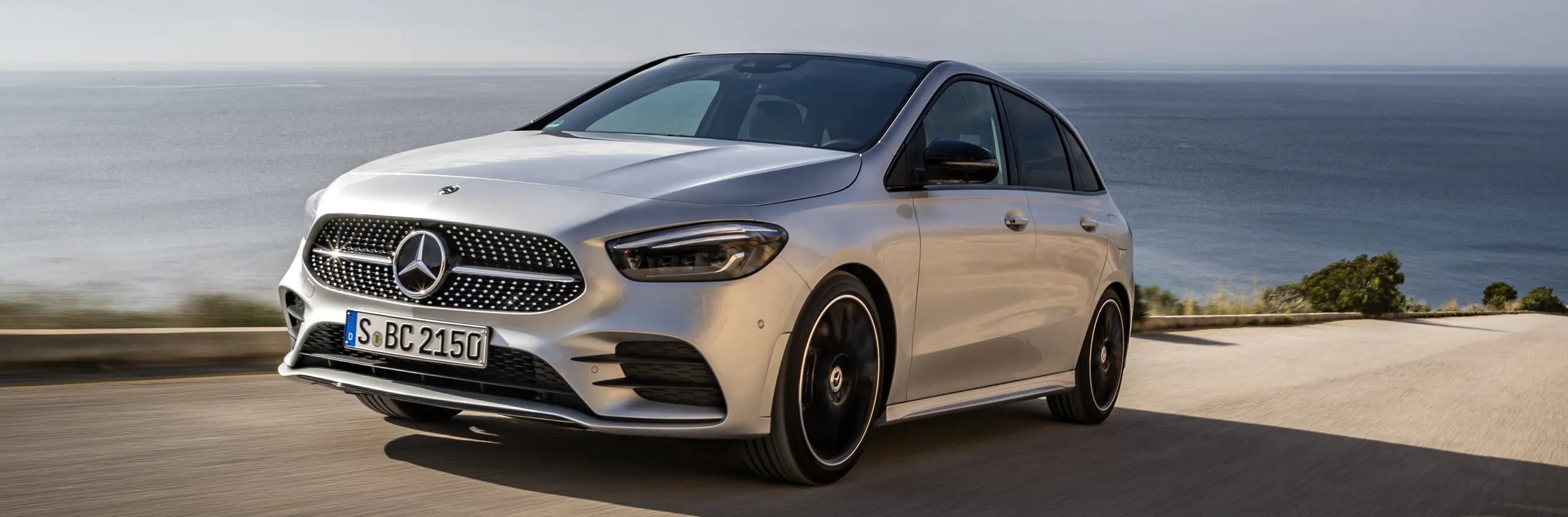Mercedes-AMG B250 blanco en carretera costera, ejemplo de eficiencia diésel