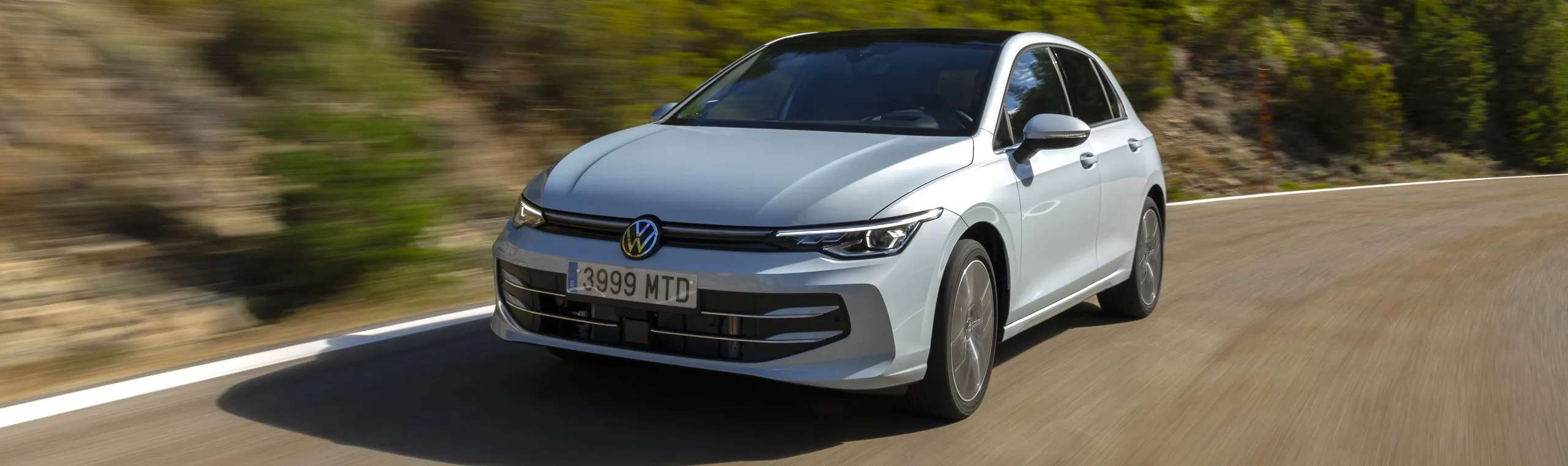 Volkswagen berlina blanca circulando por carretera, ejemplo de coche ejecutivo de gran