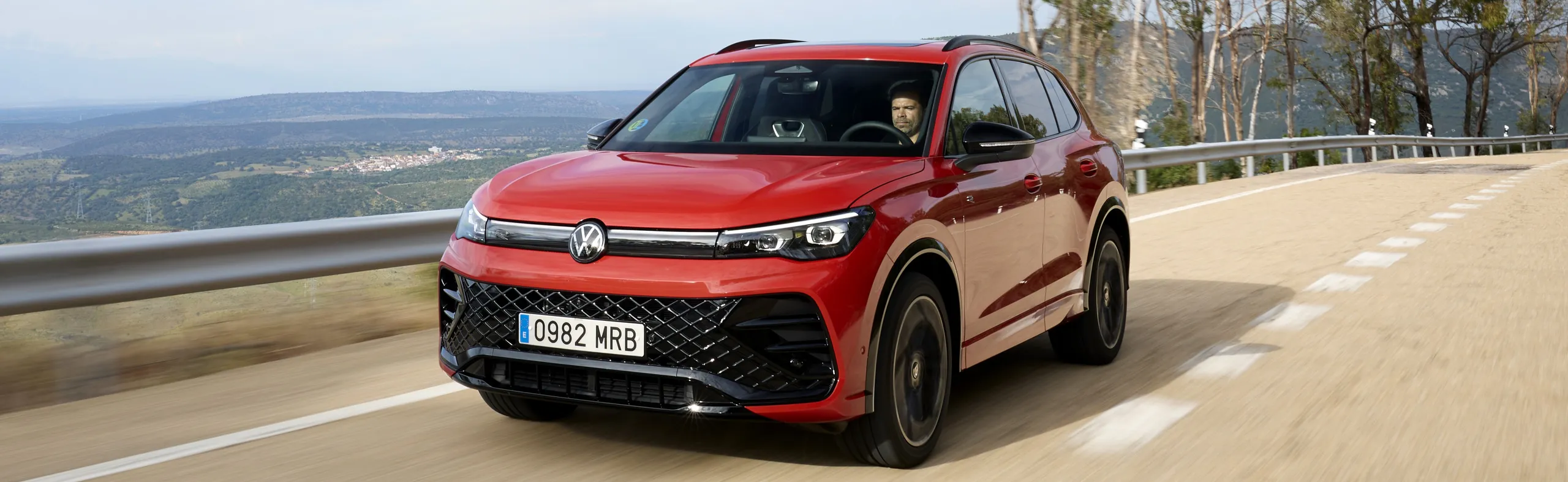 Volkswagen ID.Buzz rojo circulando por carretera de montaña con vistas al valle