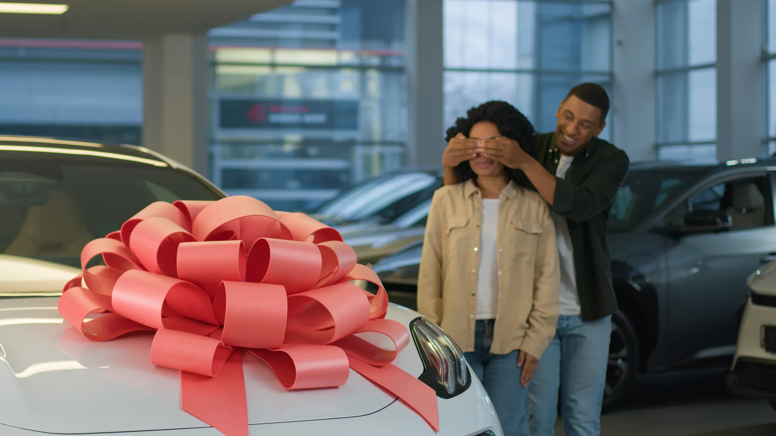 Hombre sorprende a mujer con regalo de coche nuevo en concesionario
