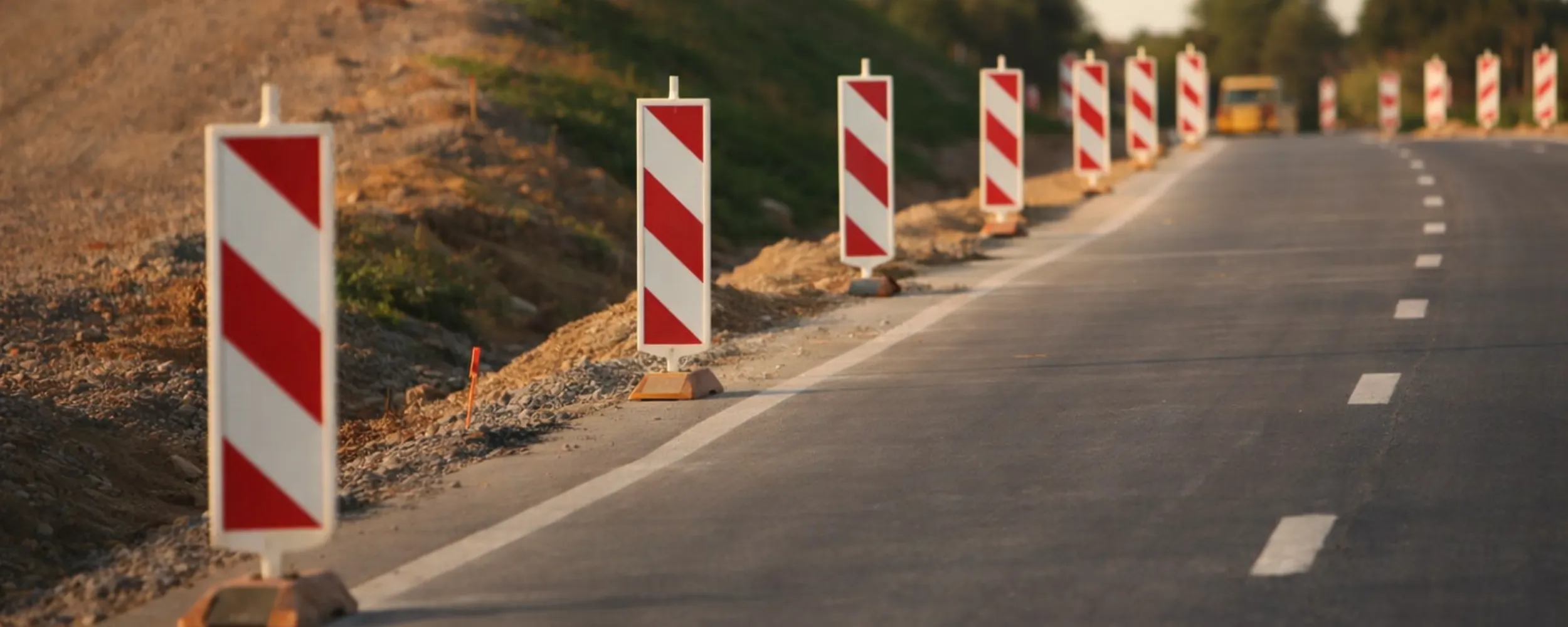 Señales de balizamiento rojo y blanco alineadas en la carretera para delimitar carriles