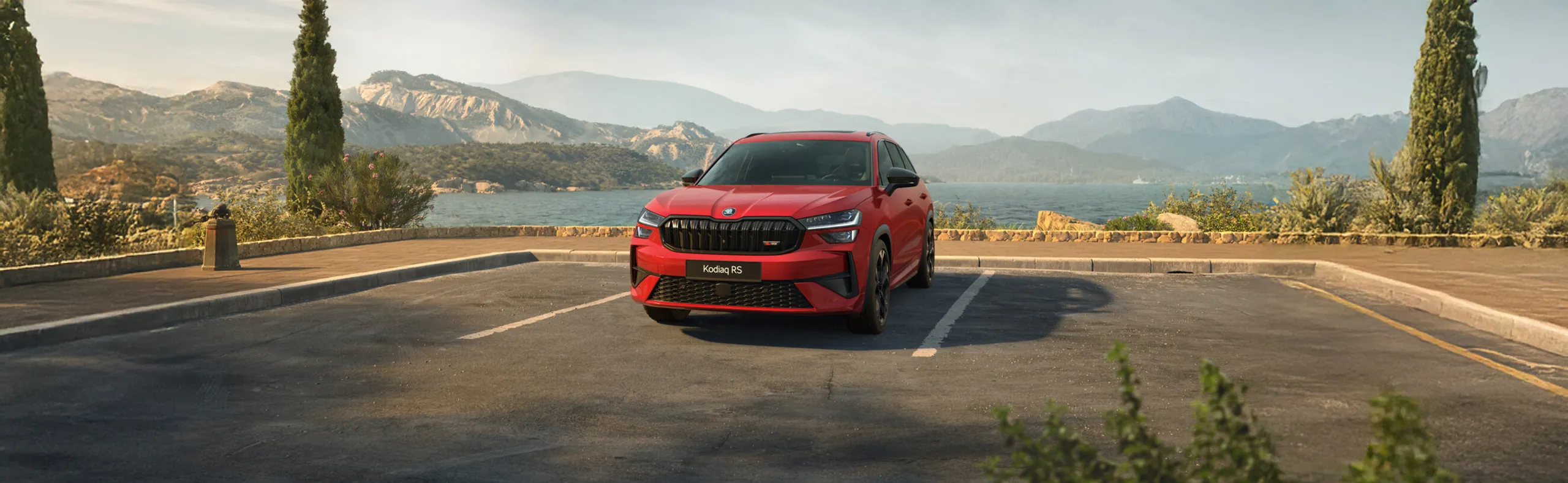 Kodiaq RS rojo aparcado en mirador con lago y montañas al fondo